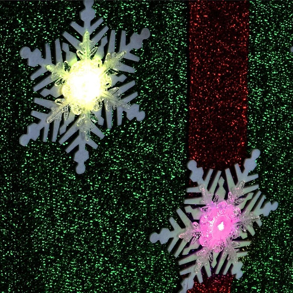 Green Christmas gift with red bow, white snowflakes and LED lights