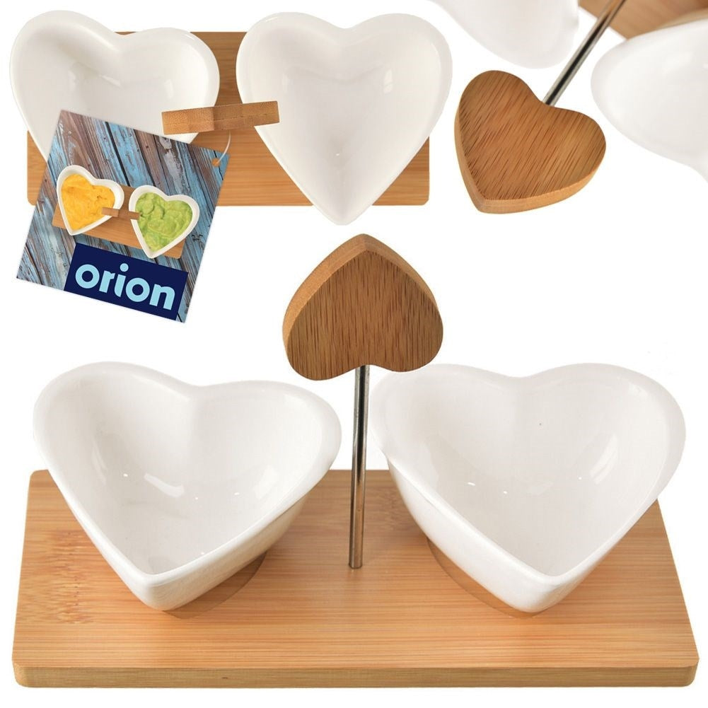 Two heart-shaped porcelain bowls on a bamboo tray for serving