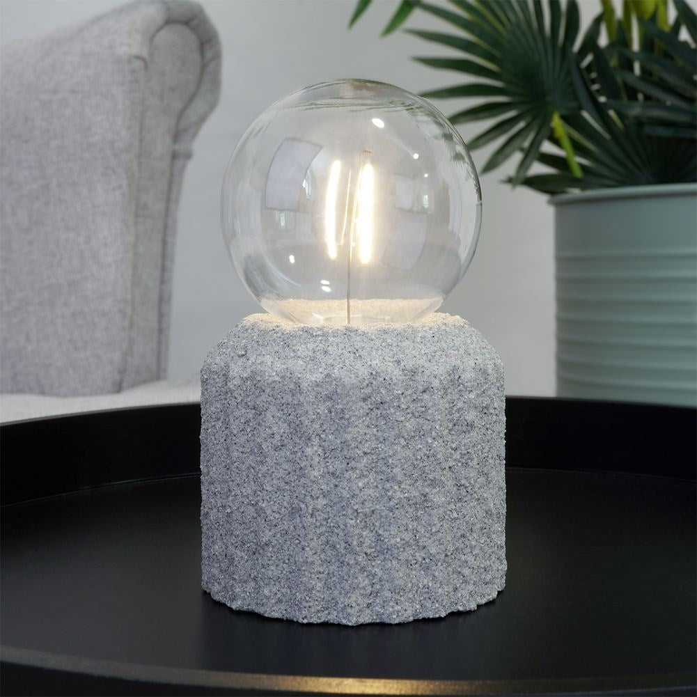 Battery-powered LED table lamp with a cement-like base