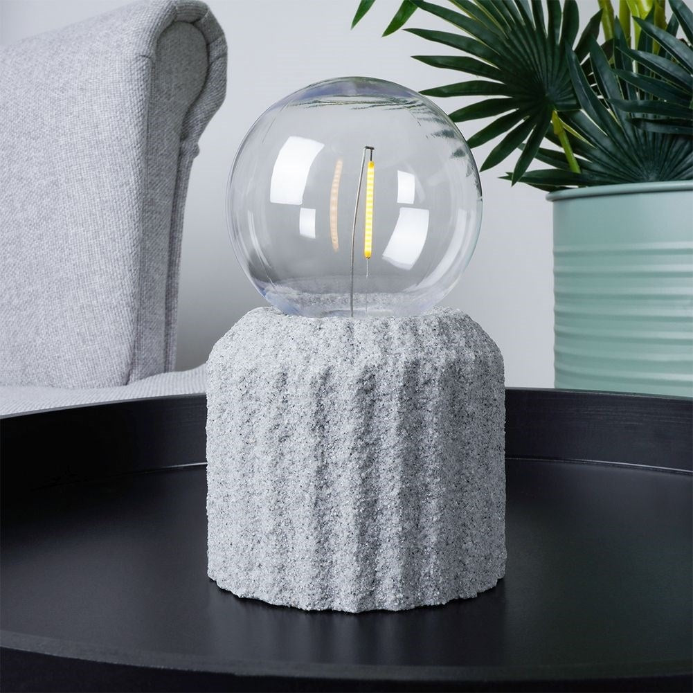 Battery-powered LED table lamp with a cement-like base