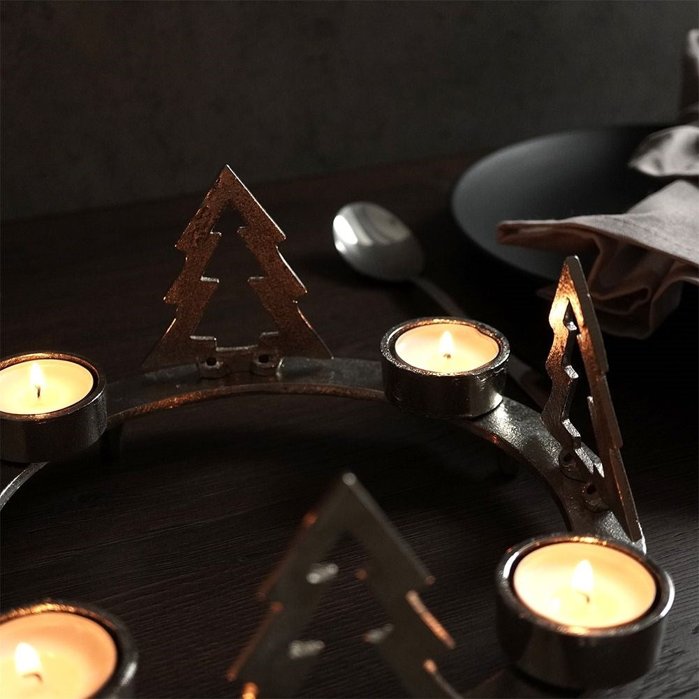 Candle holder for four candles with fir trees in silver aluminium