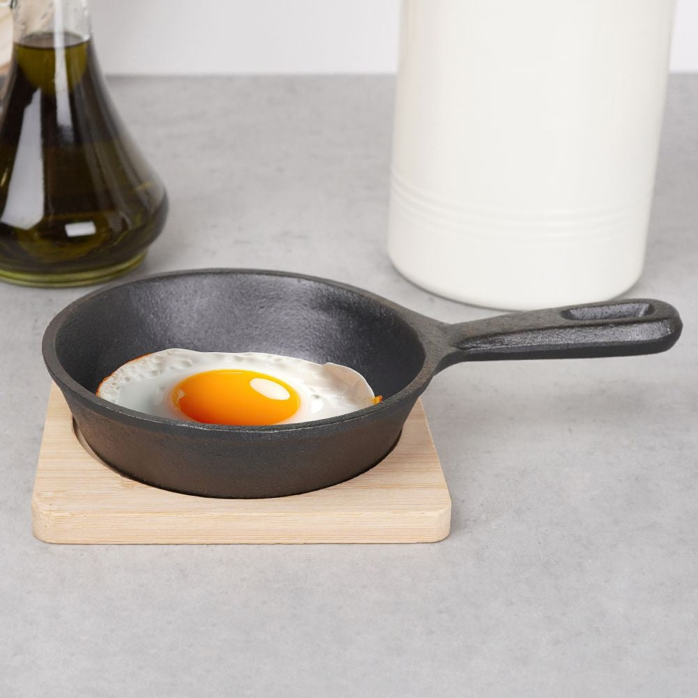 Cast iron dish with wooden tray for tapas and snacks