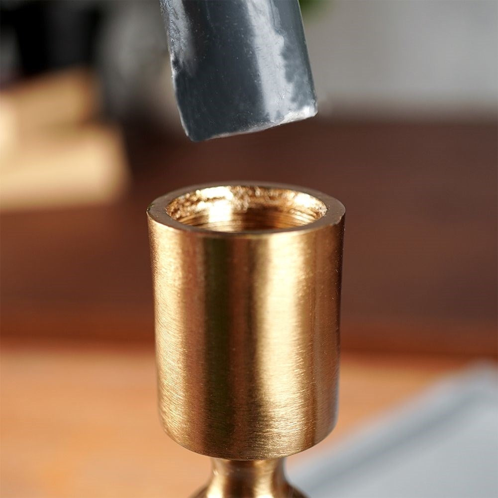 Classic candle holder in aluminum with a golden hue
