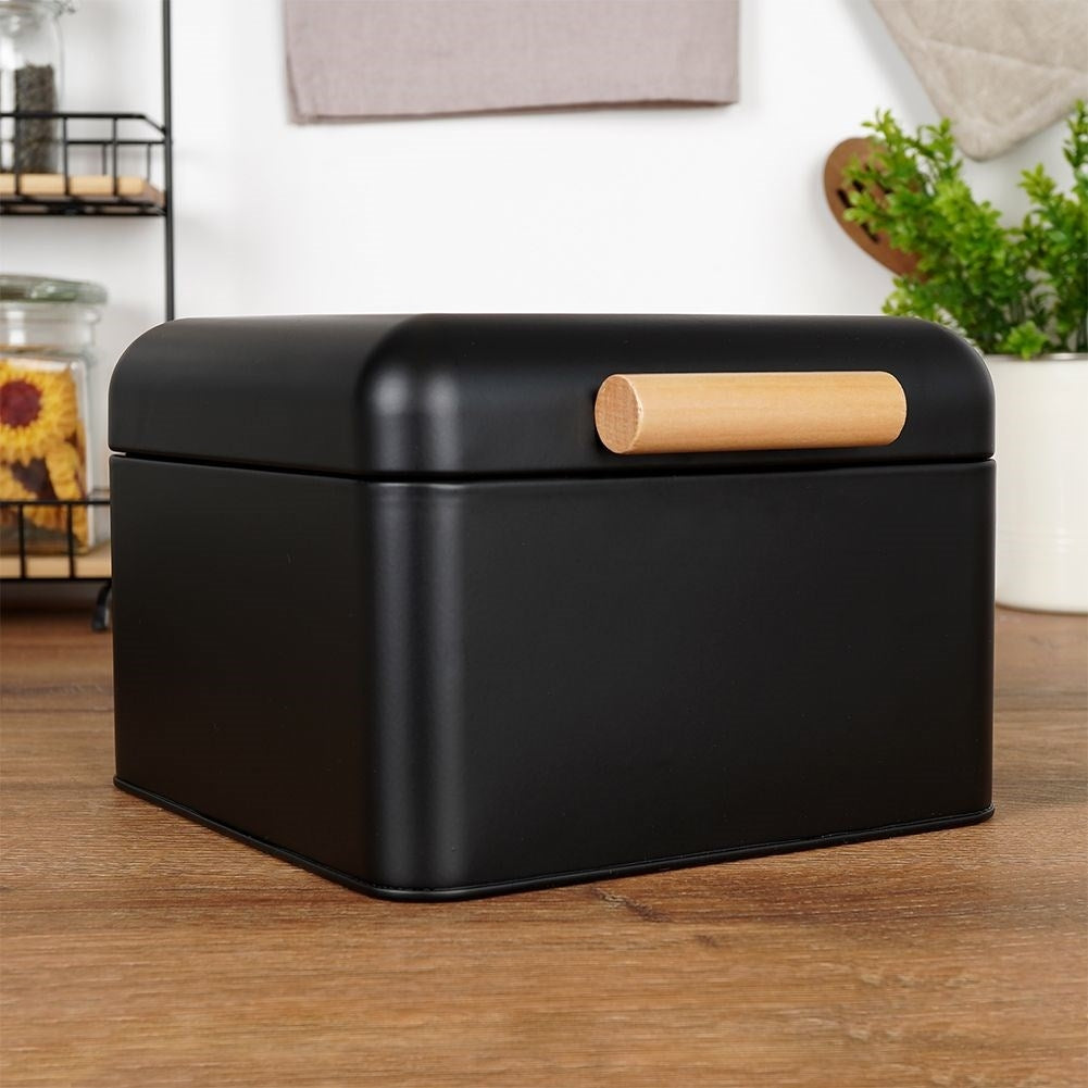 Compact black metal bread box with hinged lid