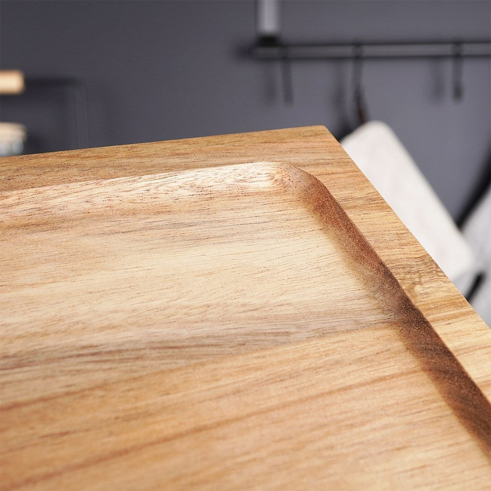 Cutting board made of acacia wood on high legs for serving