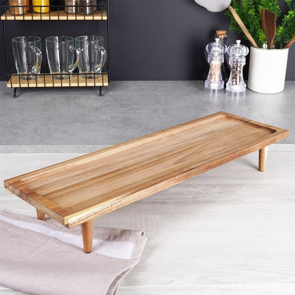Cutting board made of acacia wood on high legs for serving
