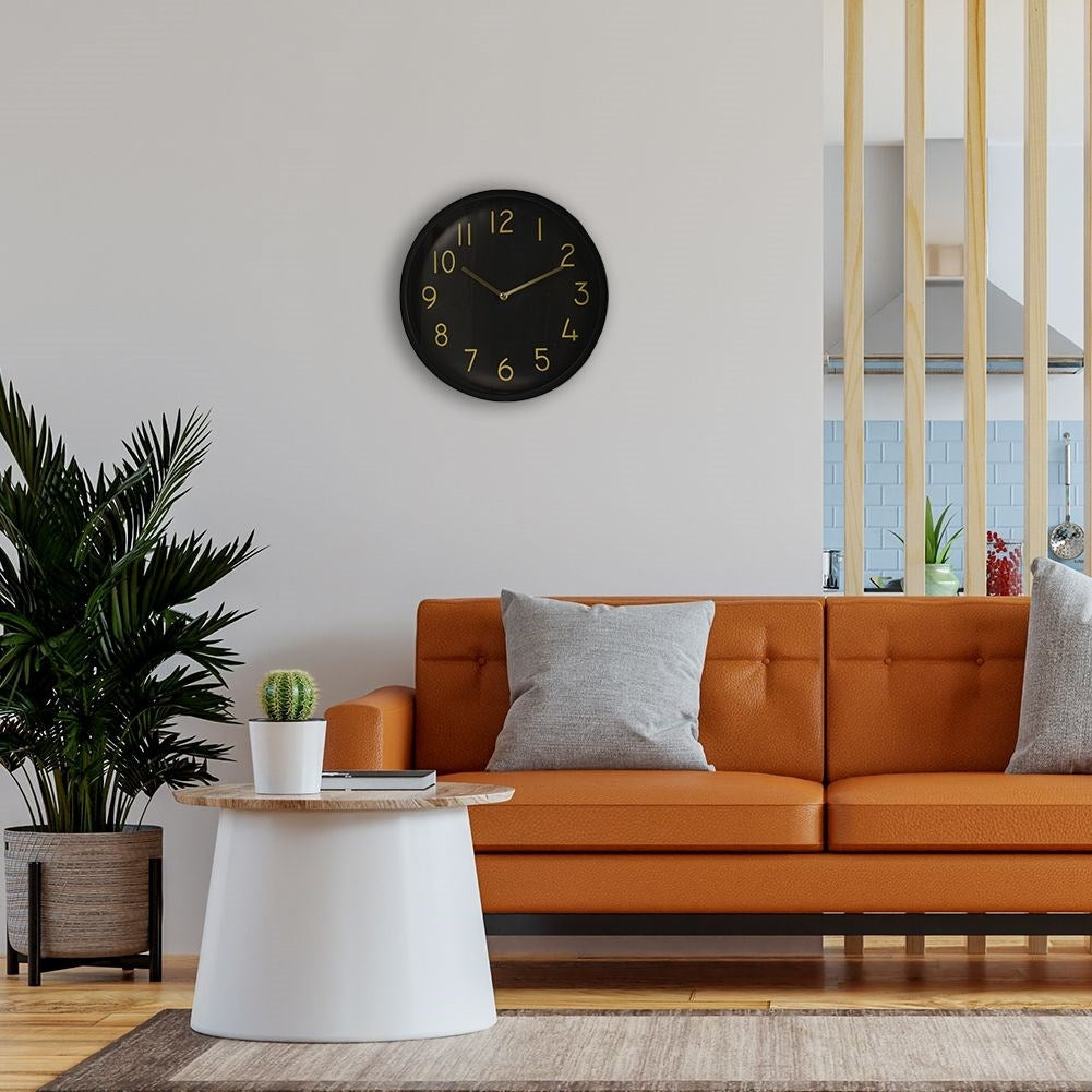 Elegant black wall clock with golden hands and numbers