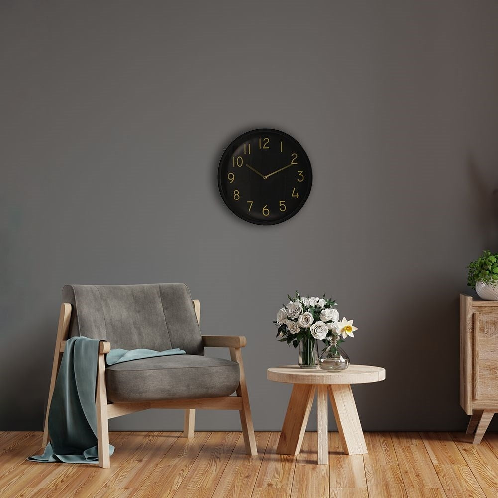 Elegant black wall clock with golden hands and numbers
