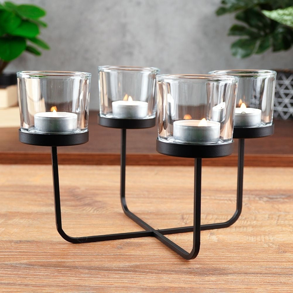 Elegant candle holder in black metal with four glass inserts