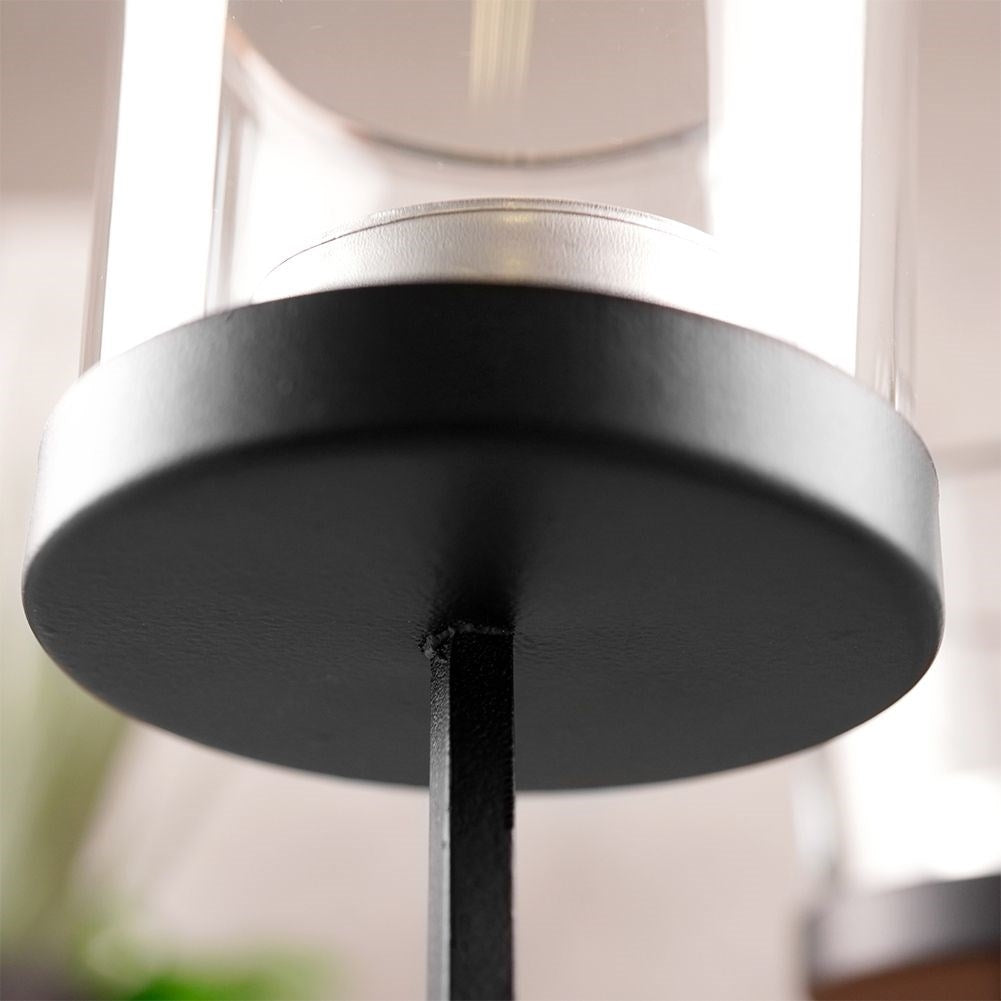 Elegant candle holder in black metal with four glass inserts