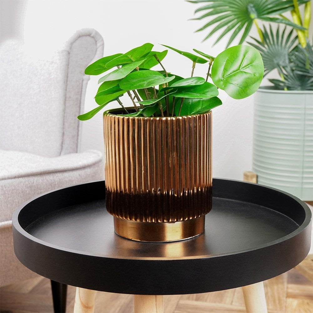 Elegant ceramic pot with ribbed surface and glossy gold colour