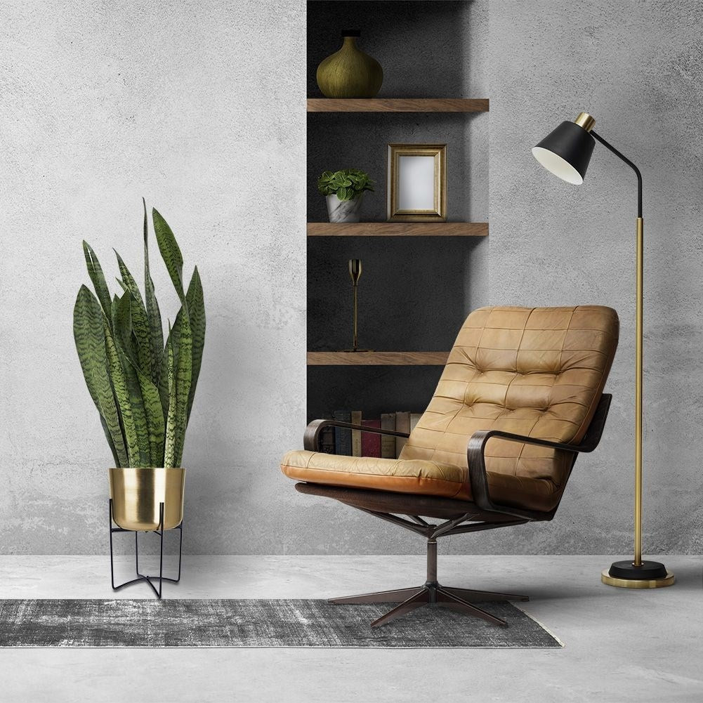 Elegant gold flower pot on black metal stand for modern interior design