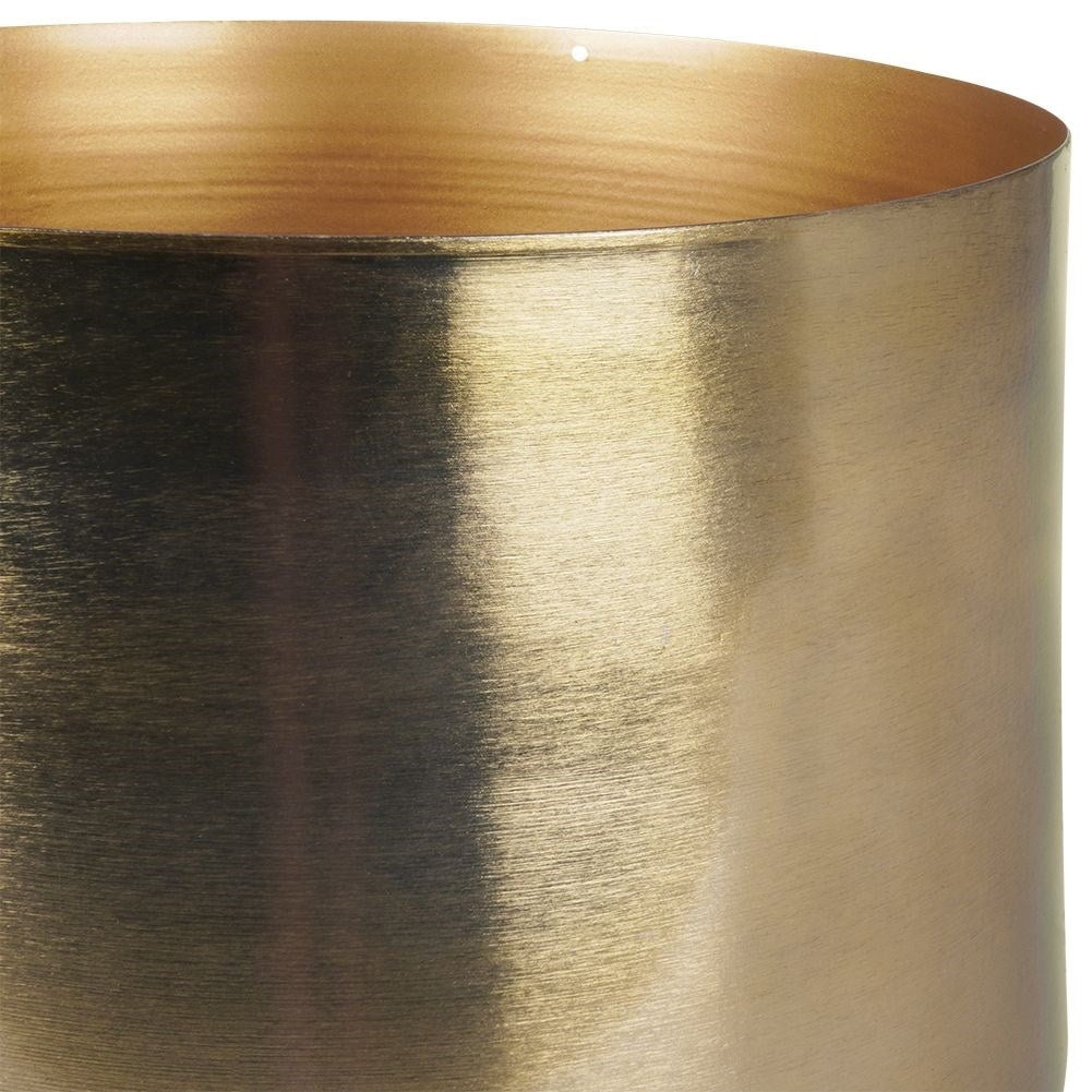 Elegant gold flower pot on black metal stand for modern interior design