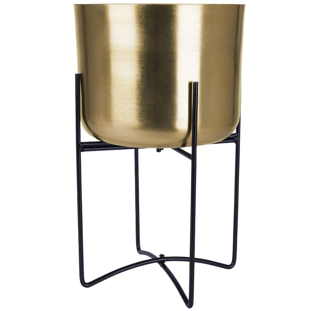 Elegant gold flower pot on black metal stand for modern interior design