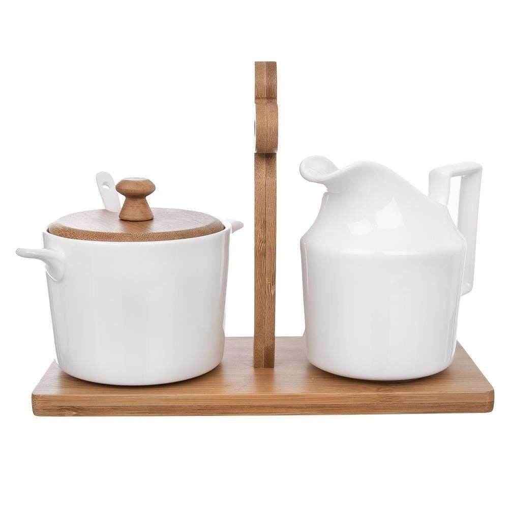 Elegant porcelain sugar bowl and cream jug on bamboo tray