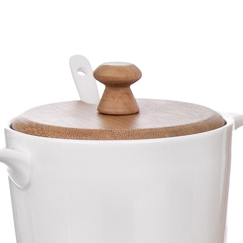 Elegant porcelain sugar bowl and cream jug on bamboo tray