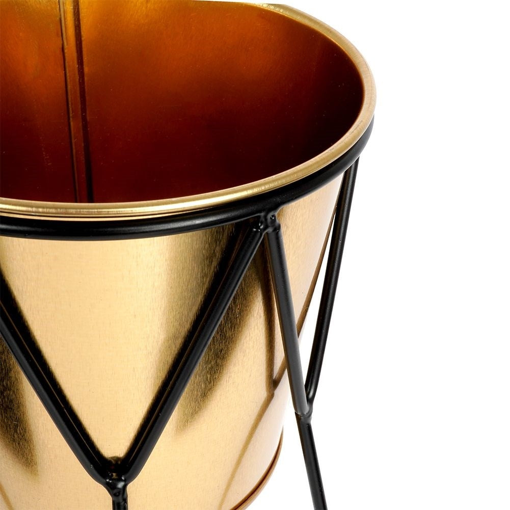 Elegant pot in gold with stylish black metal stand