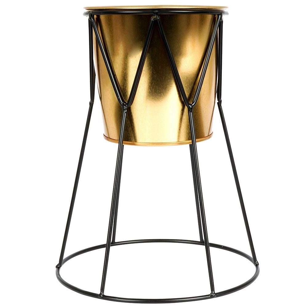 Elegant pot in gold with stylish black metal stand