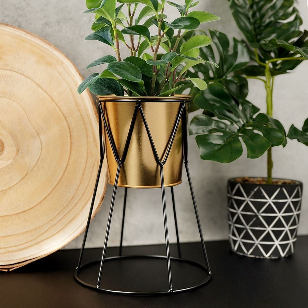 Elegant pot in gold with stylish black metal stand