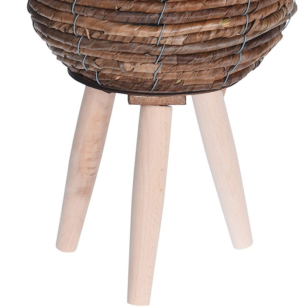 Flower pot on wooden legs. Braided from natural materials