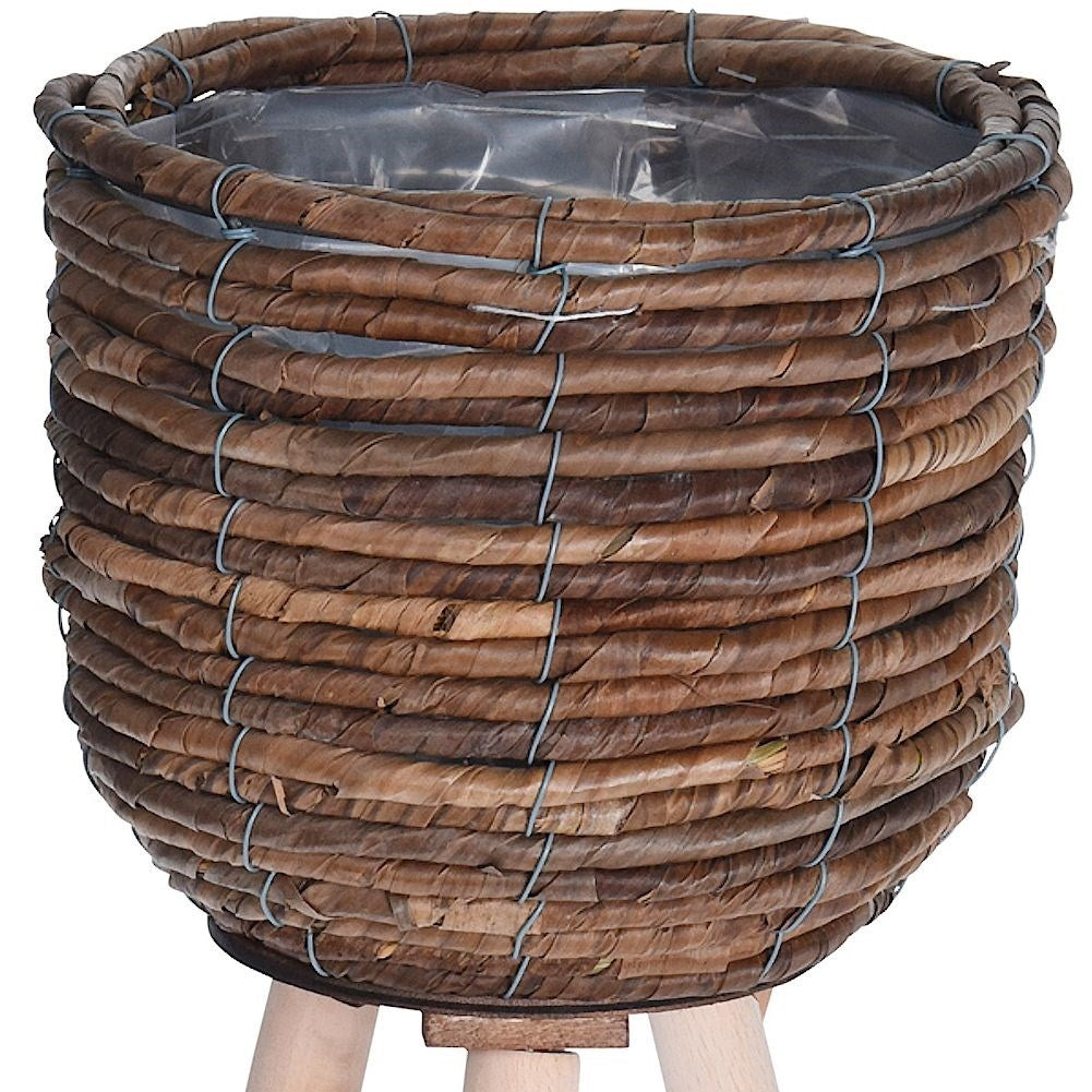 Flower pot on wooden legs. Braided from natural materials