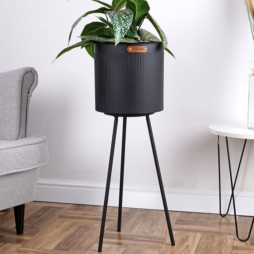 Fluted flower pot with three legs in black metal for indoor/outdoor use