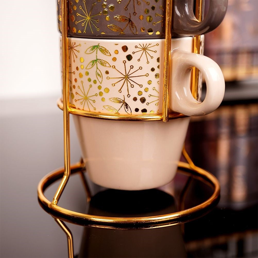 Four elegant porcelain mugs with gold stands and details