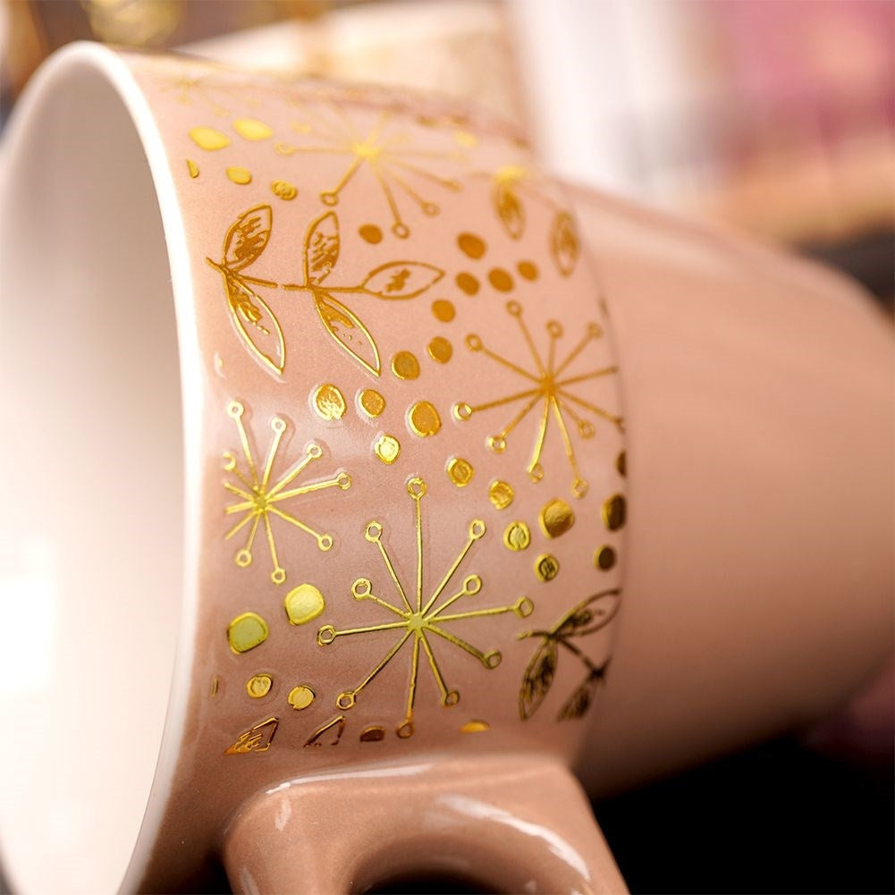 Four elegant porcelain mugs with gold stands and details