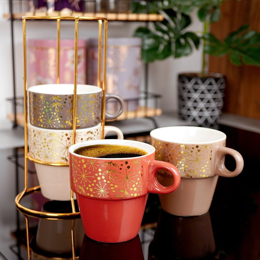 Four elegant porcelain mugs with gold stands and details