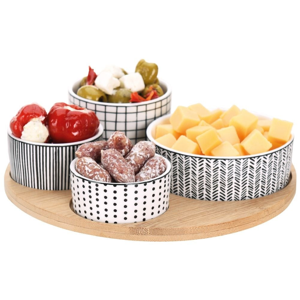 Four porcelain bowls on a bamboo tray for serving goodies