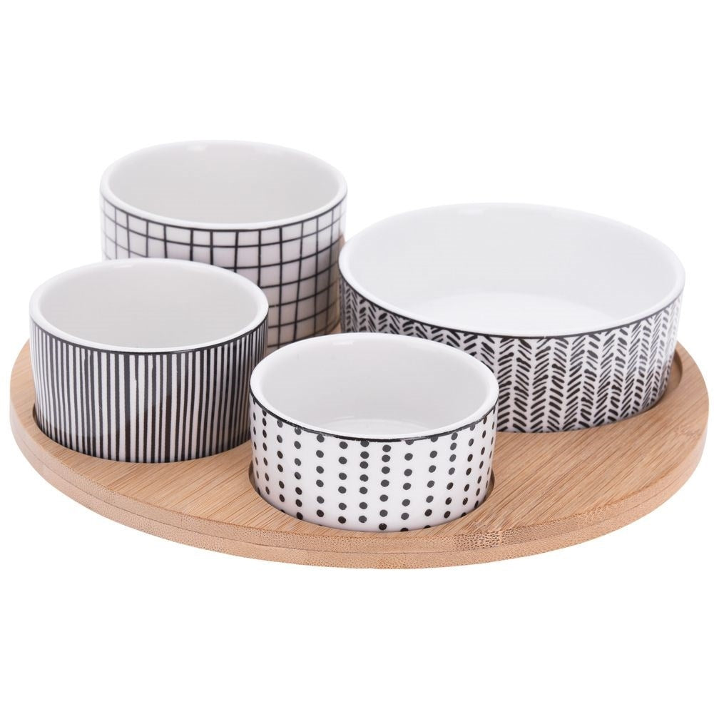 Four porcelain bowls on a bamboo tray for serving goodies