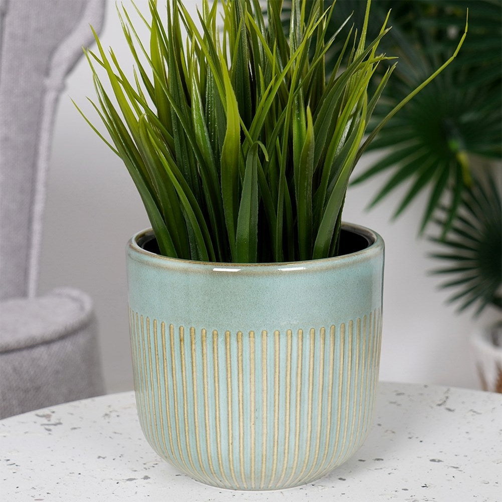 Glazed green porcelain pot with ribbed surface and subtle shine