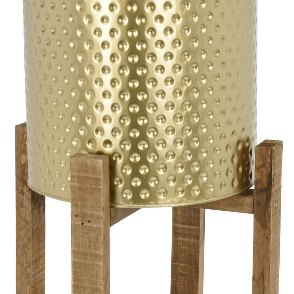 Gold colored flower pot on a wooden stand