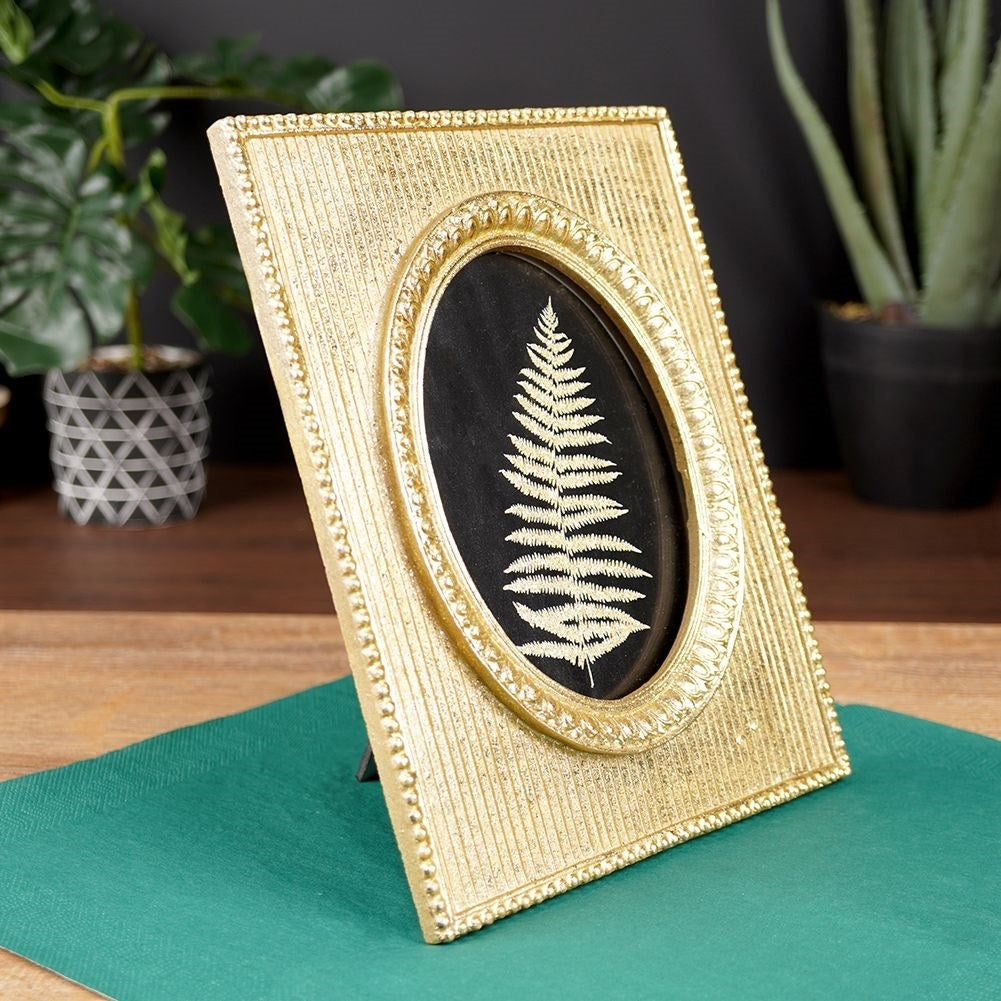 Gold-colored photo frame 10x15 cm in synthetic stone
