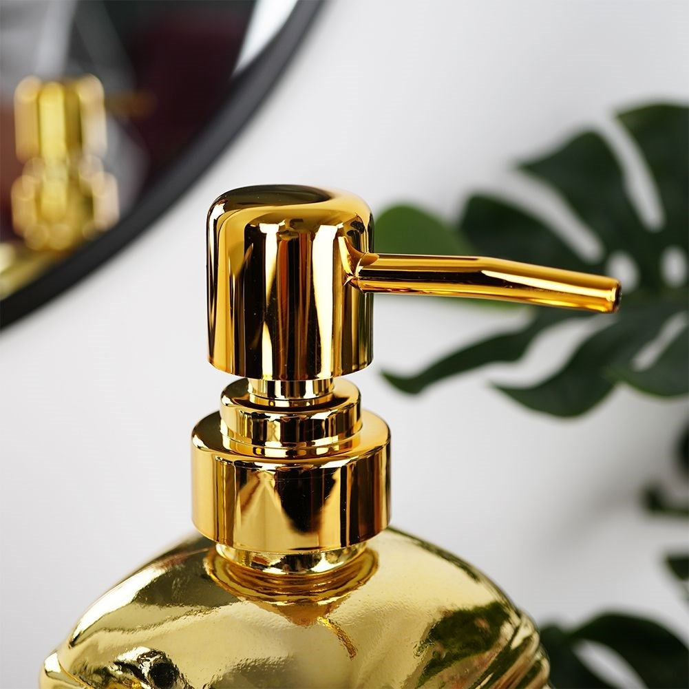 Gold colored soap pump in glass for kitchen and bathroom