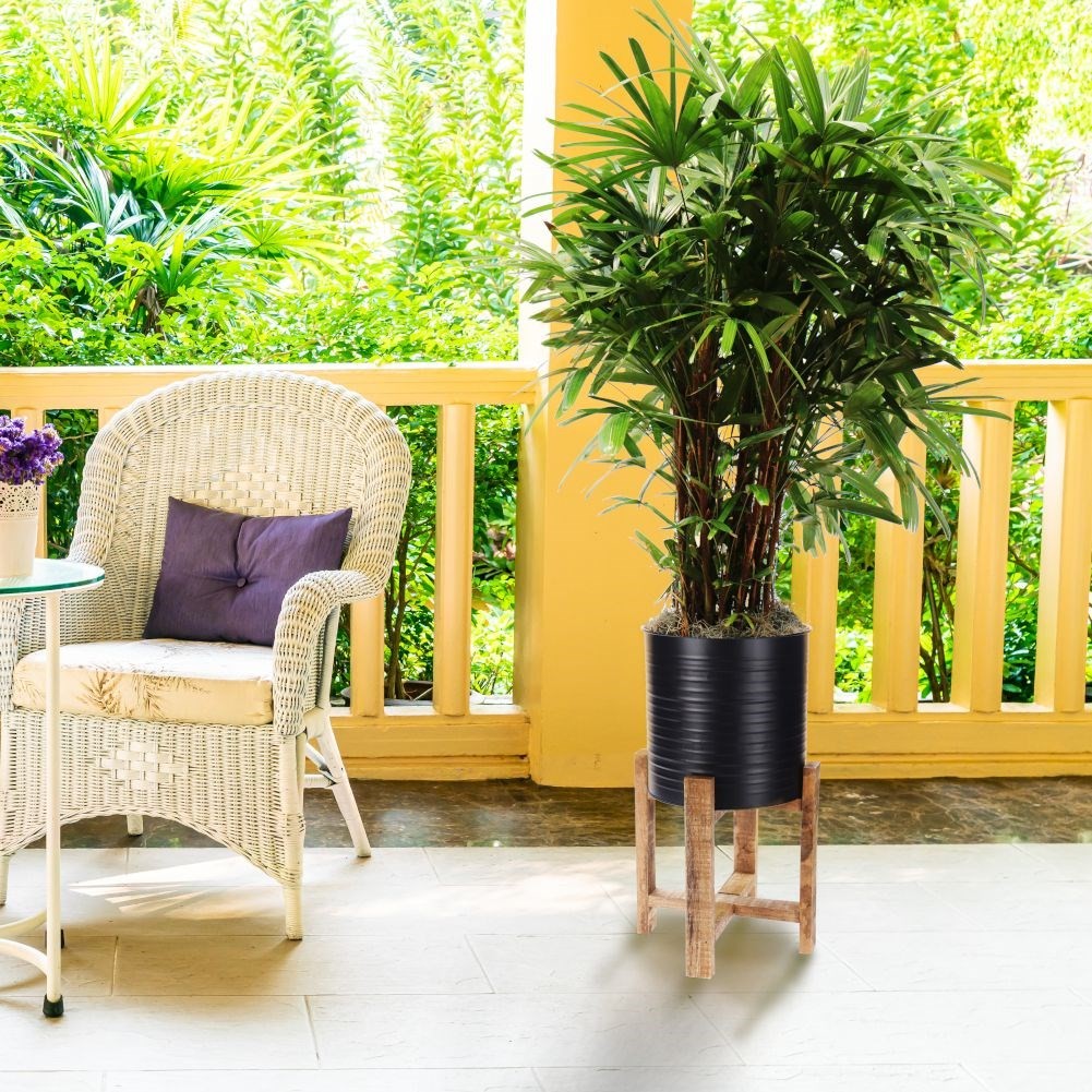 Metal flower pot on a wooden stand for modern interior design
