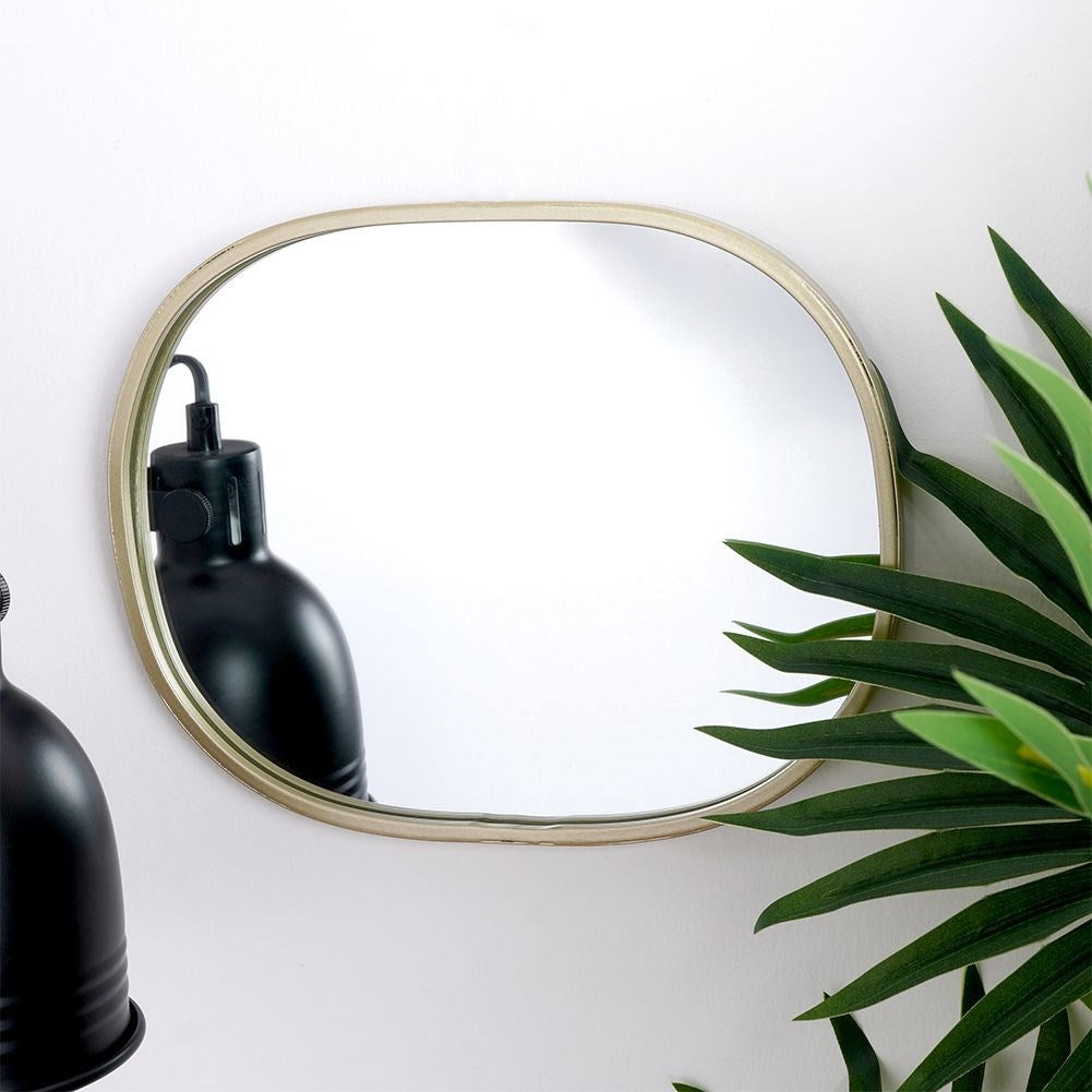 Oval wall mirror with champagne gold frame - elegant detail