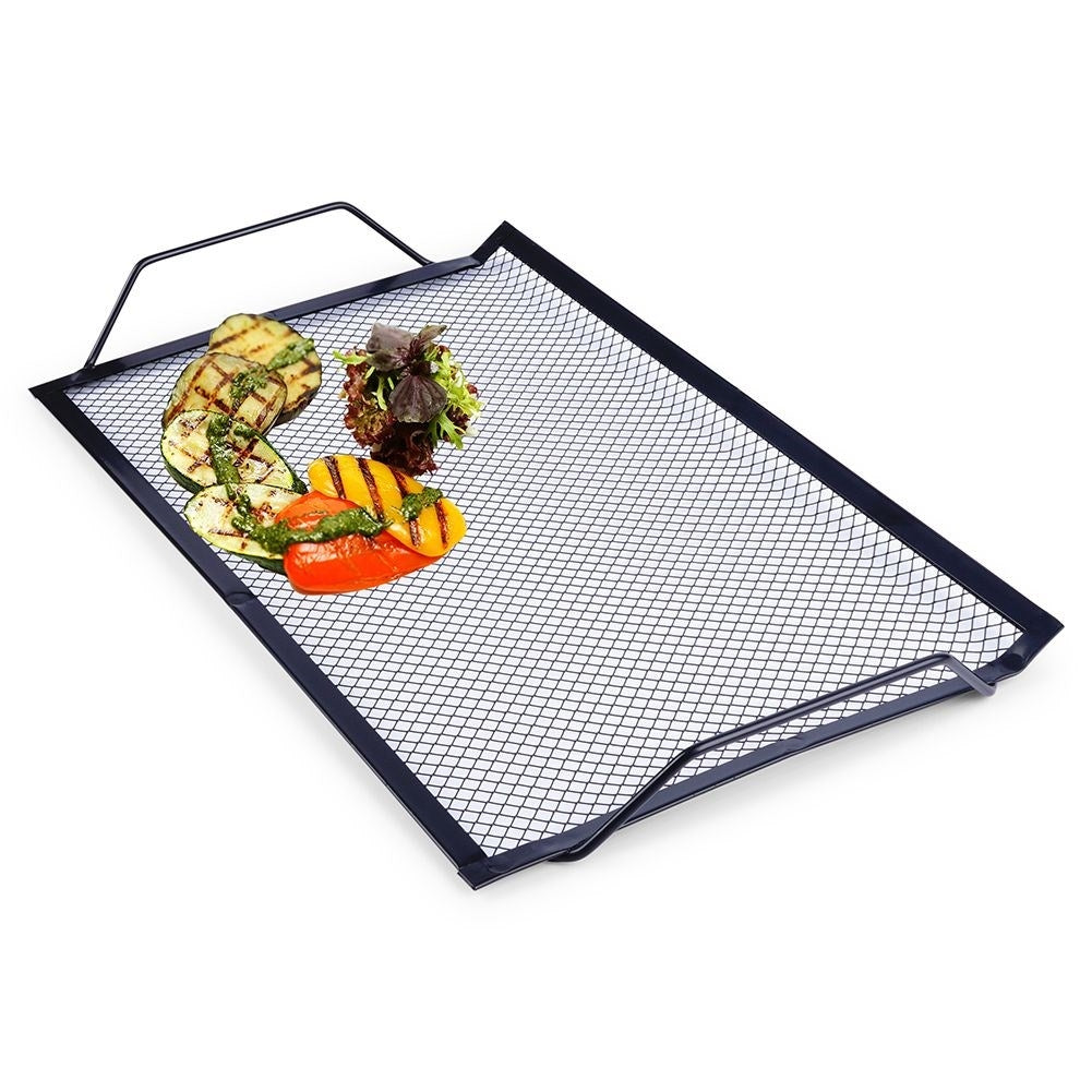 Perforated grill plate in black metal for meat and vegetables