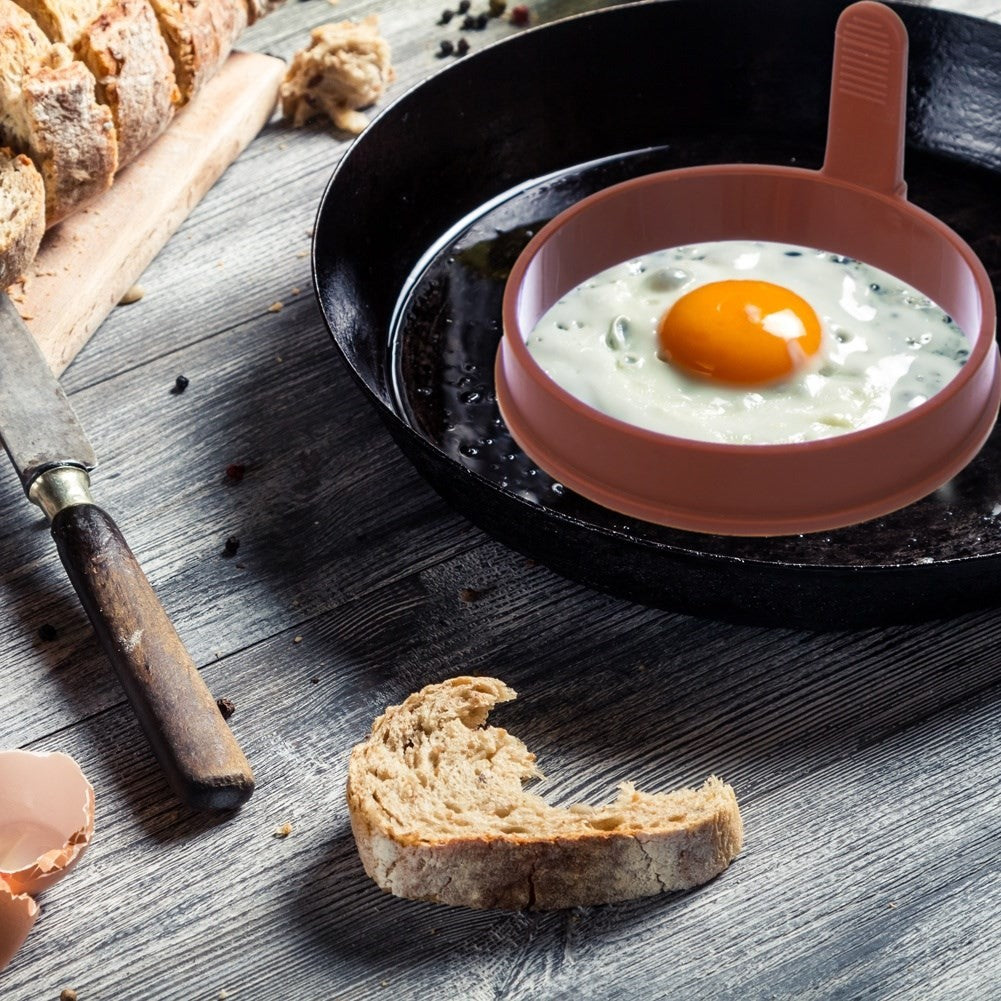 Round brown silicone mold for eggs and pancakes with handle
