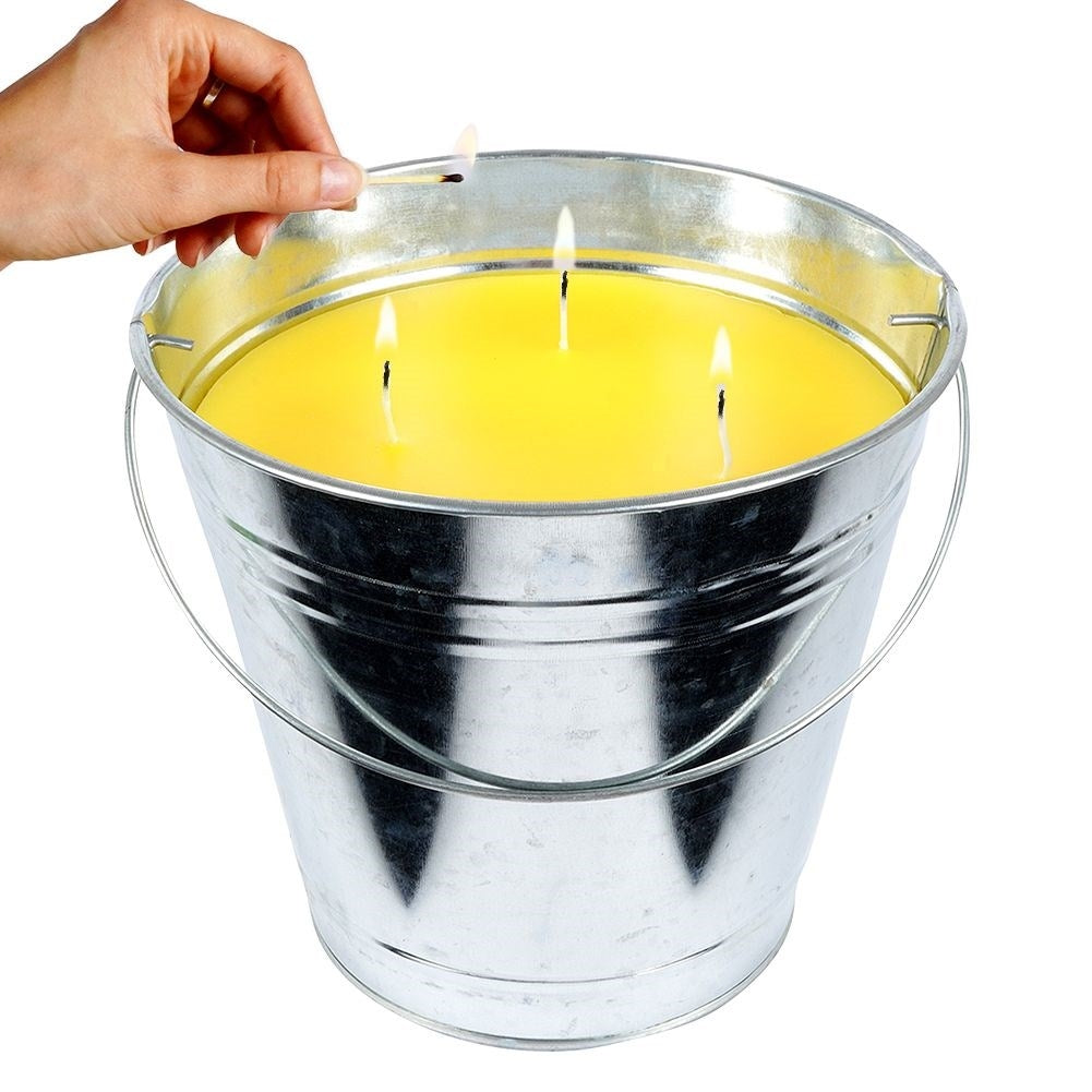 Scented candle with lemon scent and essential oil in a metal bucket