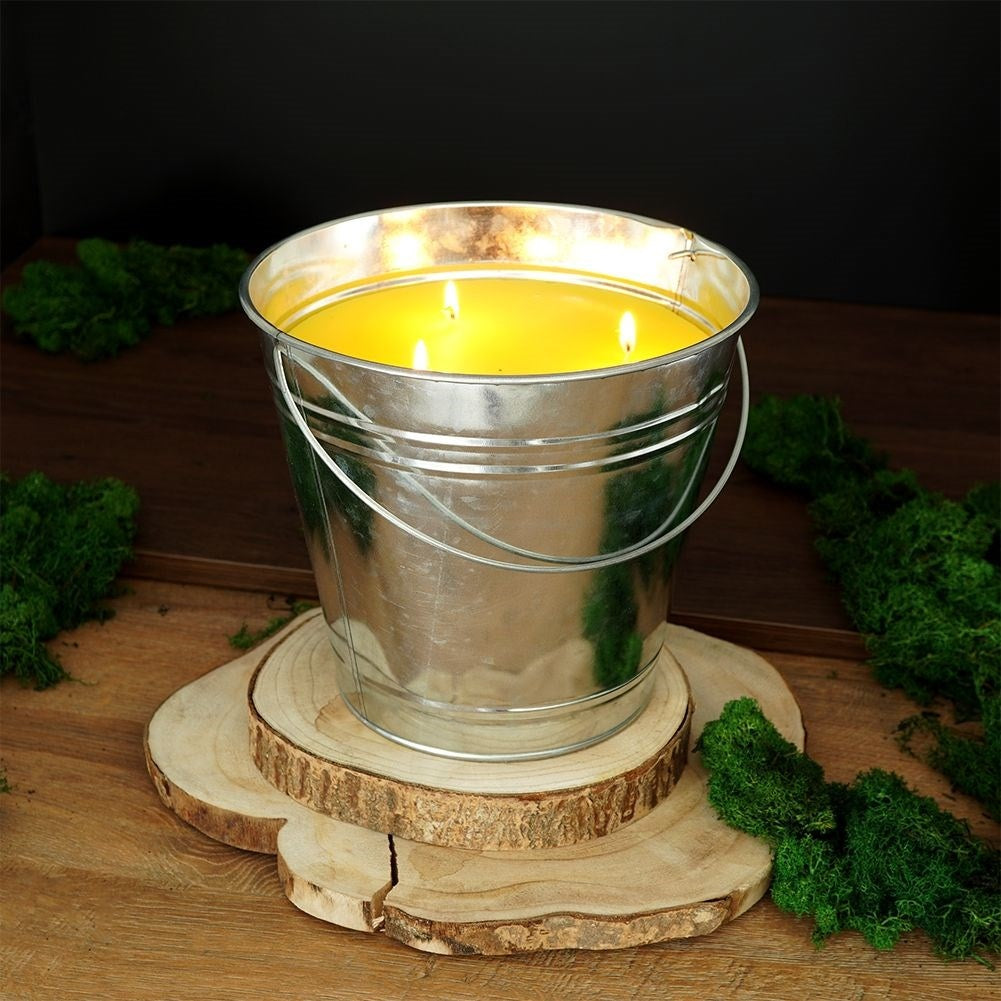 Scented candle with lemon scent and essential oil in a metal bucket