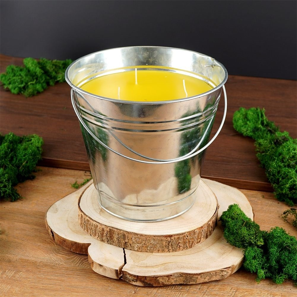 Scented candle with lemon scent and essential oil in a metal bucket