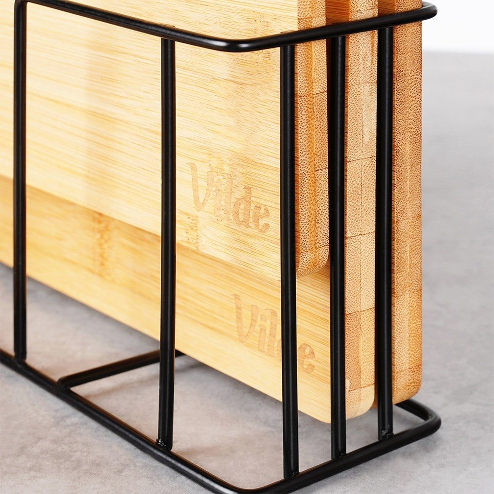 Set of bamboo cutting boards in a metal stand with a unique design