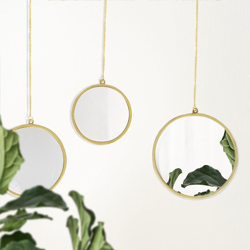 Set of three elegant wall mirrors with golden frames