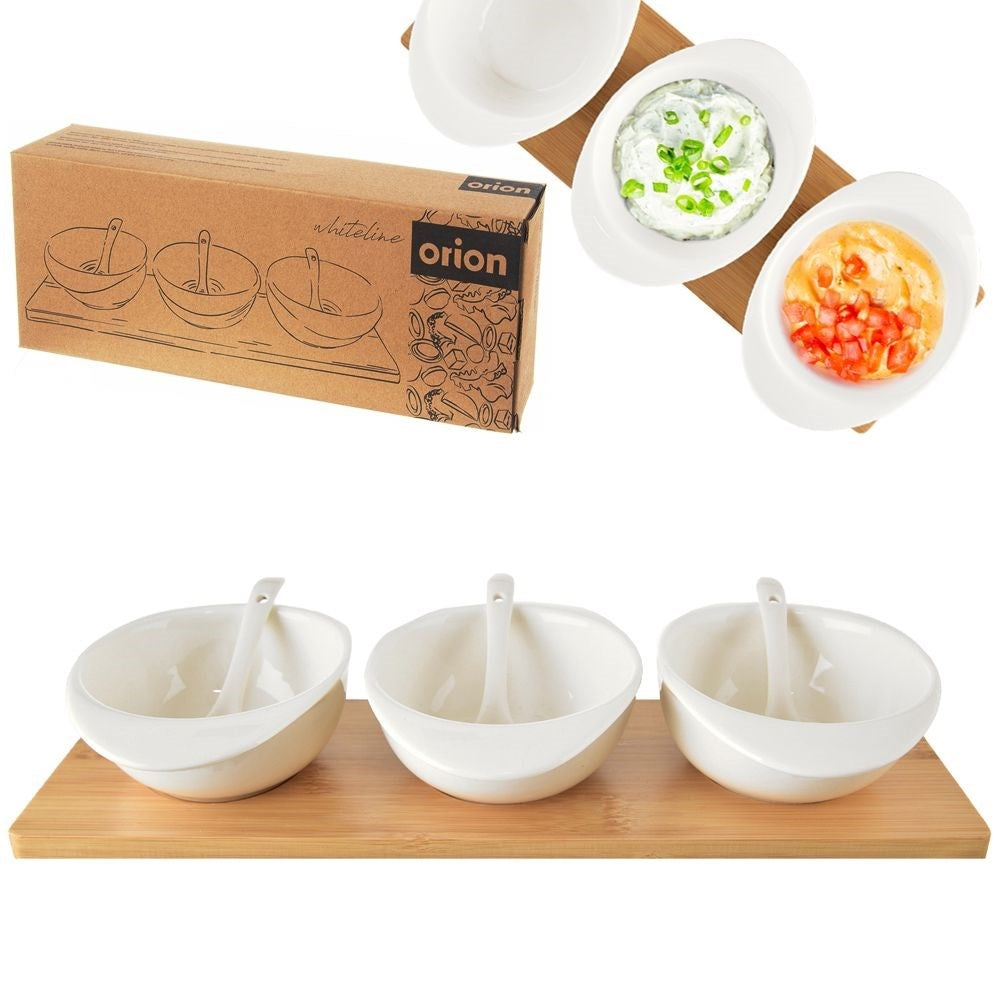 Set of three porcelain bowls and spoons on a bamboo tray