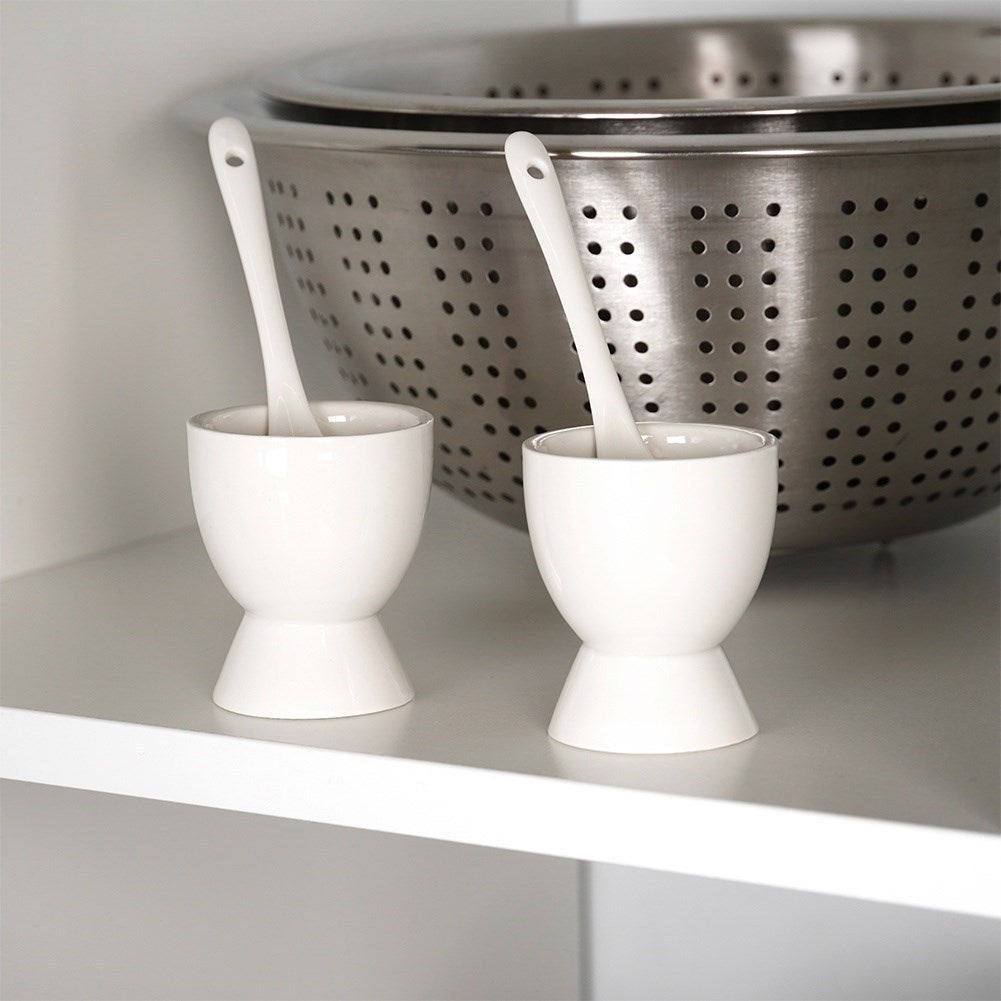 Set of two white porcelain egg cups with spoons