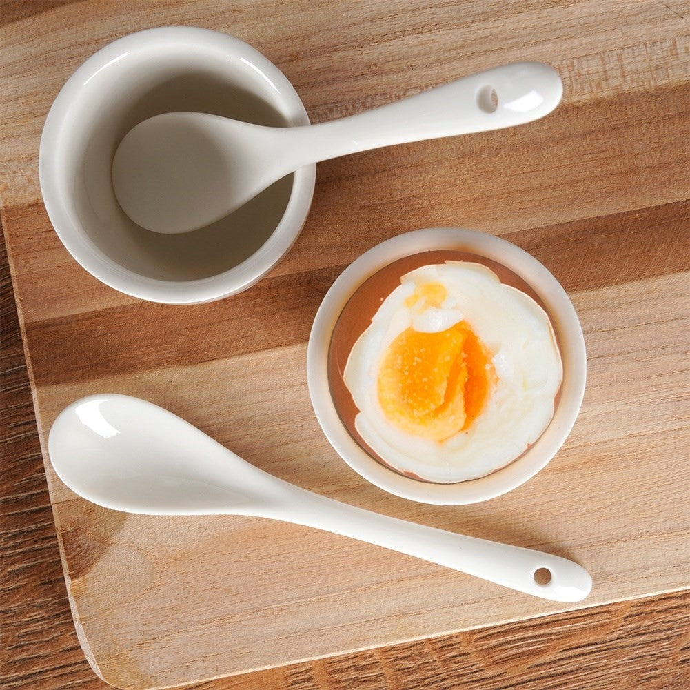 Set of two white porcelain egg cups with spoons