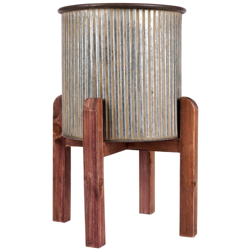 Silver colored fluted flower pot on a wooden stand