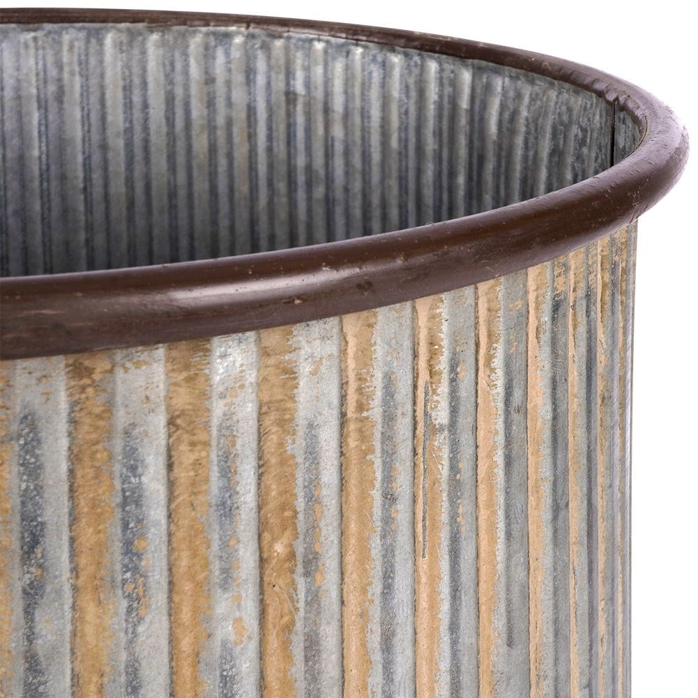 Silver colored fluted flower pot on a wooden stand