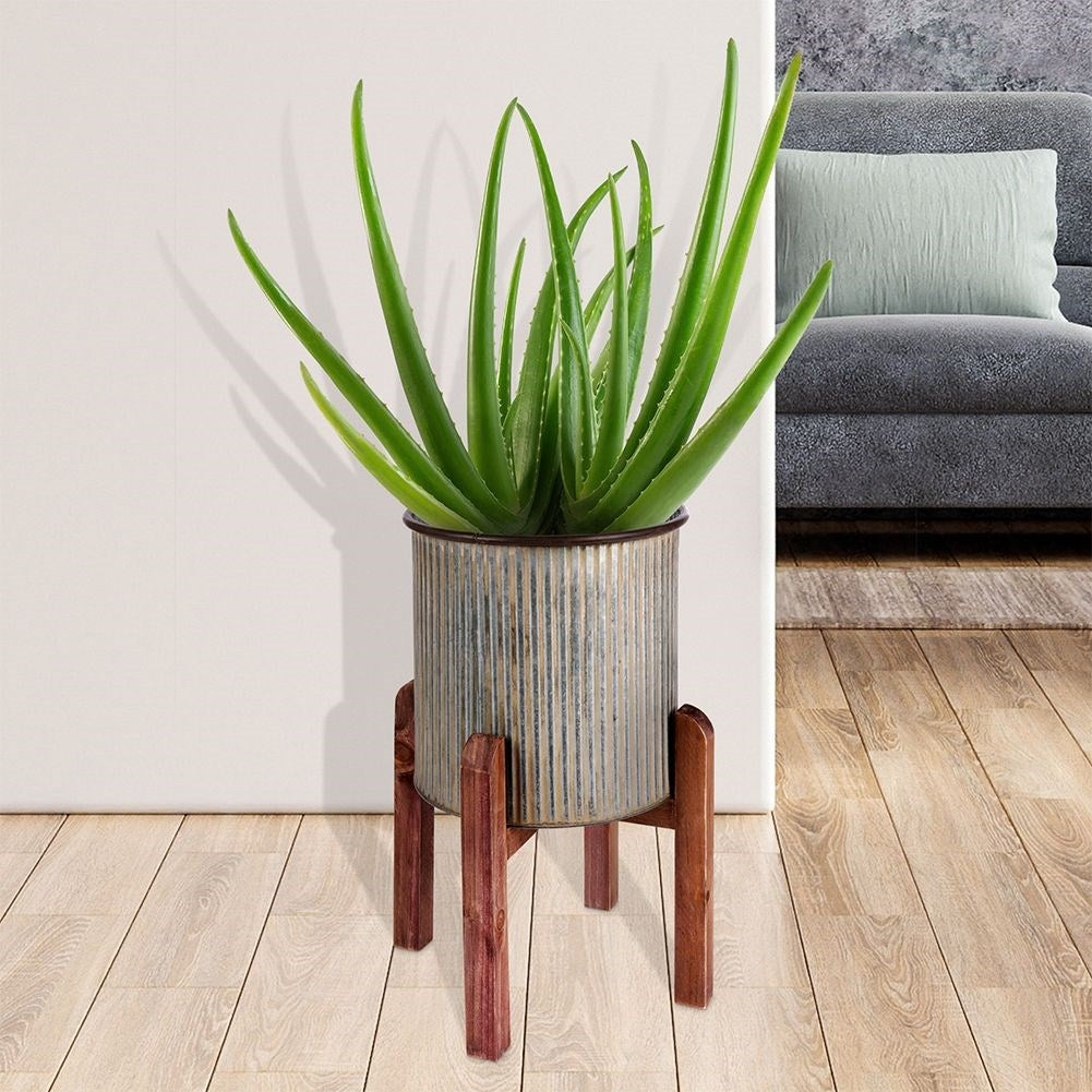 Silver colored fluted flower pot on a wooden stand